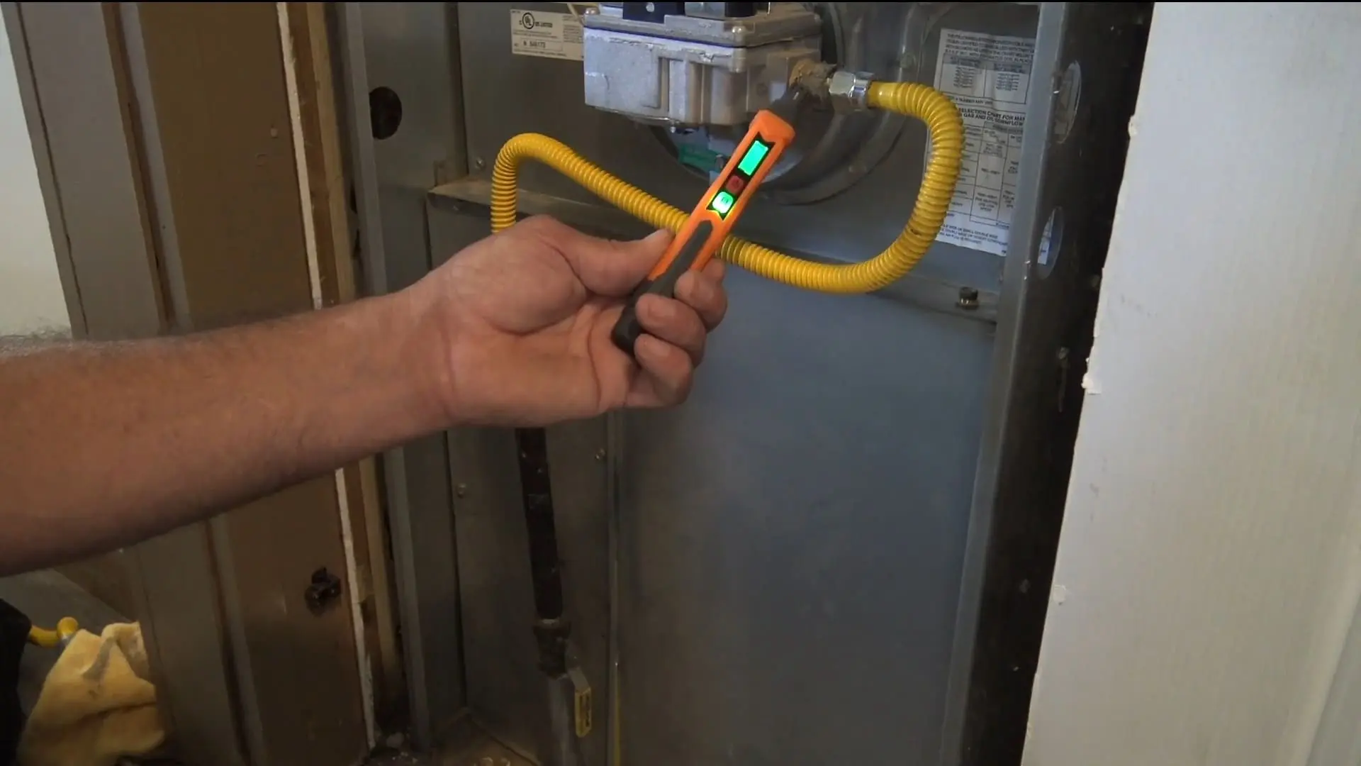 Electronic gas leak sniffer inspecting a furnace during a Chicago detection visit