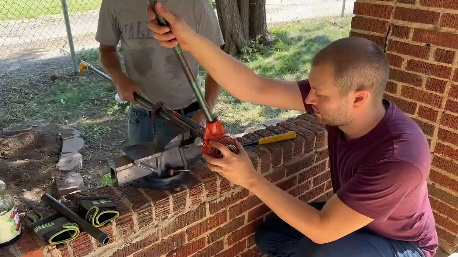Gas pipe held in a vise being cut and threaded for a Chicago meter relocation